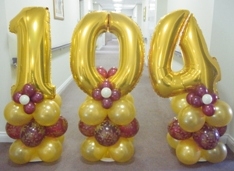 Age 104 Gold And Burgundy air filled balloons